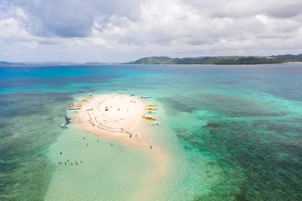 İnsanlar tropikal bir adada rahatlar ve gölde yüzerler. Çıplak Ada, Siargao. Turistler teknelerle beyaz adaya geldiler. Beyaz kumlu ada.