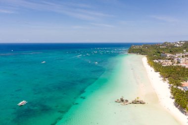 Boracay Adası, Filipinler, yukarıdan manzara. Palmiye ağaçları ve tekneli turkuaz bir göl. Büyük adadaki binalar ve oteller.