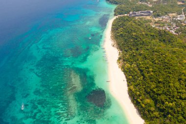 Puka Deniz Kabuğu Sahili. Beyaz kumlu geniş tropikal plaj. Filipinler 'in Boracay adasında güzel beyaz plaj ve gök mavisi su manzarası. Turistler sahilde dinlenir..