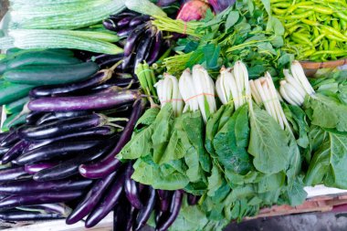 Tezgahta çeşitli sebzeler var. Market tezgahında organik taze meyve ve sebzeler. Asya 'da sebze satmak.