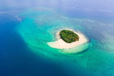 Mavi denizde kumlu bir sahil olan tropik bir ada. Mercan resifleri var. Rosa Adası, Filipinler. Seyahat konsepti: Tropikal kum plajı ve turkuaz su manzarası..