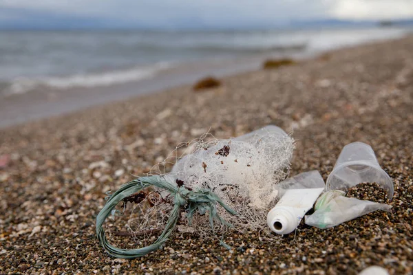 Beach pollution. Plastic bottles and other trash on sea beach. Ocean pollution. Plastic trash on the seashore.