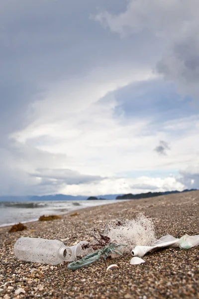 Beach pollution. Plastic bottles and other trash on sea beach. Ocean pollution. Plastic trash on the seashore.