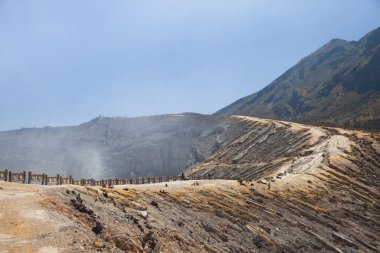 Ijen Volkanı, Endonezya. İşçiler volkan kraterinden sülfür çıkarıyorlar. Sülfür madenciliği.
