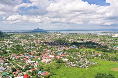 Tacloban şehri, Leyte Adası, Filipinler. Şehrin manzaralı tropikal manzarası, yukarıdan manzaralı. Kümülüs bulutlu şehir ve gökyüzü.