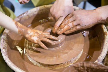 Ellerini çömlek çarkına koy. Potter eli. Çömlek çarkında kil çömlekçisi yaratıyor