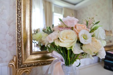 Aynanın yanında güzel bir buket çiçek. Beyaz güzel düğün buketi aynanın yanında duruyor. Ayna yansıması.