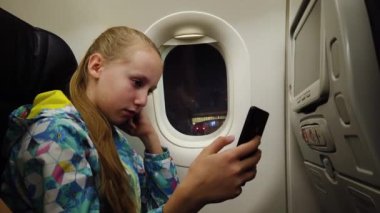 Uçakta cep telefonu olan bir kız..