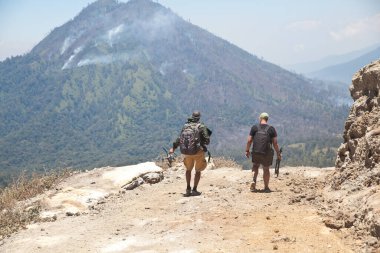 Dağlarda gezginler. İki adam dağ yolunda yürüyor..