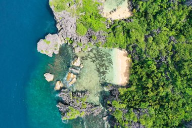 Matukad Adası, Caramoan Adaları, Filipinler. Vahşi beyaz kumsal. Yaz ve seyahat tatili konsepti. Beyaz kumlu plajı olan Rocky Adası, manzaralı. Okyanus dalgaları, sahil ve kayalık kıyı şeridi ve güzel orman manzarası..