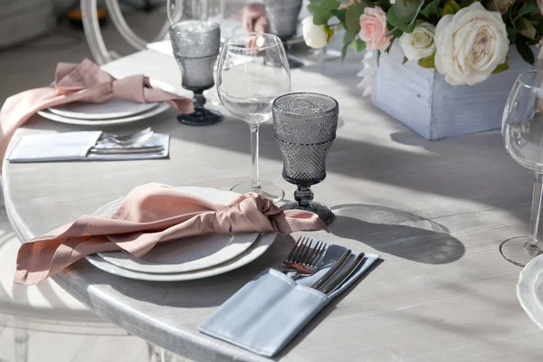 服务的桌子 宴会厅和婚宴 餐厅预订了餐桌 桌上的花和餐具 图库照片
