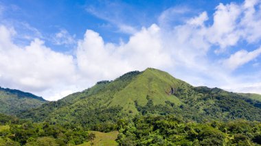 Yeşil tepeli dağ manzarası ormanlı dağlar dağ vadisi ve bulutlu mavi gökyüzü. Filipinler, Luzon. Yaz manzarası.