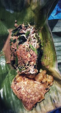 Geleneksel bir Endonezya yemeği muz yaprağında servis edilir, baharatlı sambal ve dilimlenmiş baharatlı sebzelerle karıştırılır. Sokak yemekleri kültürü ve yerel tatlar.