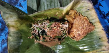 Geleneksel bir Endonezya yemeği muz yaprağında servis edilir, baharatlı sambal ve dilimlenmiş baharatlı sebzelerle karıştırılır. Sokak yemekleri kültürü ve yerel tatlar.