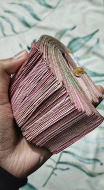 Potrait bir adamın elinde 100.000 rupia değerinde bir tomar Endonezya rupia banknotu var. 10 milyon rupi değerinde..