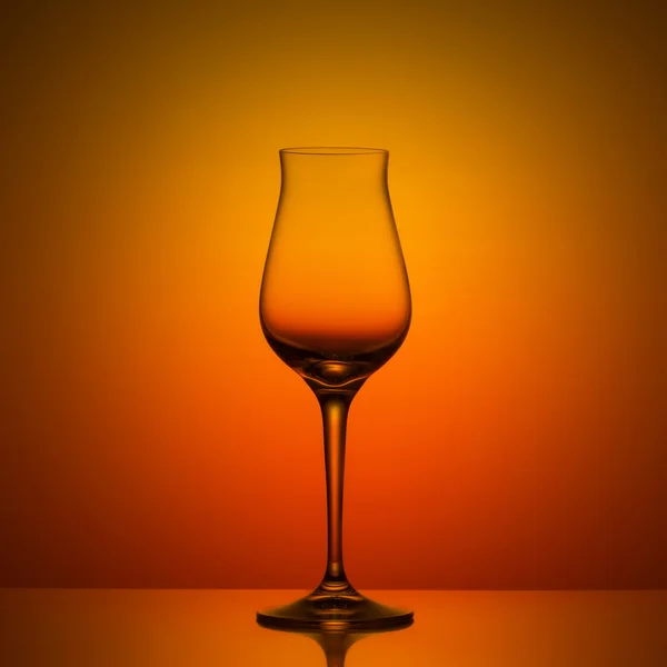 オレンジ色の背景の空のワイングラス — ストック写真