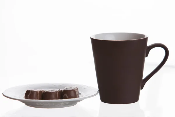 Cup and soucer with chocolate candies — Stock Photo, Image