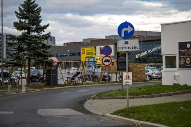 19 Ekim 2025, Varşova, Polonya: Polonya 'da sayısız trafik ve düzenleyici tabelaların, bir otoparkın ve bulutlu sonbahar gökyüzü altında iş binalarının yer aldığı ticari bir alan