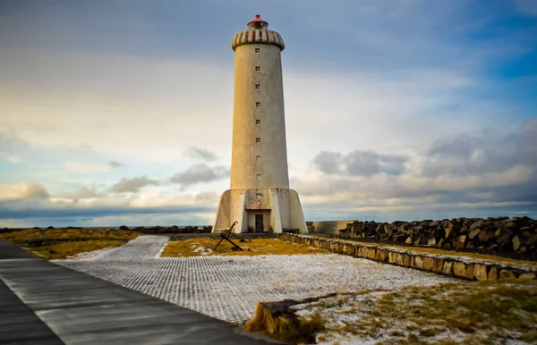 Kıyıdaki deniz feneri kulesi bulutlu kuzey gökyüzünün altında