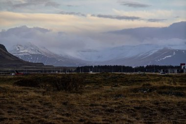 Akranes, İzlanda yakınlarında bulutlu gökyüzü ile karla kaplı dağlar
