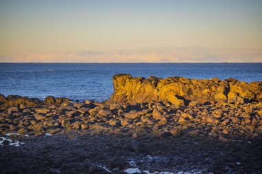 Altın günbatımında Rocky sahili