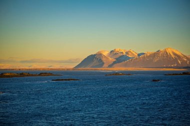 Soğuk okyanusun üzerindeki güneşli kış dağları