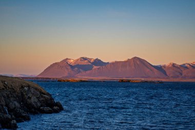 Akranes, İzlanda 'da Günbatımında Derin Mavi Okyanus' un Üzerinde Görkemli Dağ Sırası