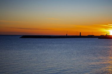 Atlantik Okyanusu üzerinde canlı Altın Gün batımı Akranes Limanı, İzlanda Deniz feneri siluetiyle