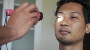 The doctor makes a test for the sensitivity of the pupils of the eyes by shining a flashlight into the eye of the patient