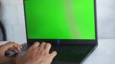 Worker scrolling touchpad green screen laptop at office workplace close up.
