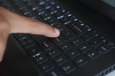 Close Up of Finger Pressing Enter Key on Modern Keyboard Showcasing Advanced Technology and Automation Shaping Future of Interaction with Devices
