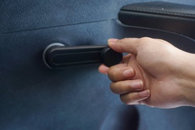Hand operating a manual car window crank
