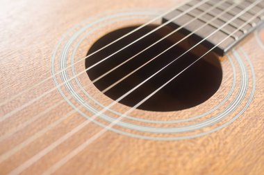 Kafa derisi. Akustik gitarın ahşap dokusuna ve sanatsal işçiliğine odaklanmış detaylı bir yakın çekimi. Spor ve eğlence kulübü pazarlaması için tasarlanmış özel rehberler, kulüp bültenleri..