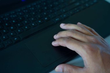 Parmaklar, modern teknoloji ve kullanıcı arayüzü erişimini vurgulayan dizüstü bilgisayarla etkileşime giriyor.