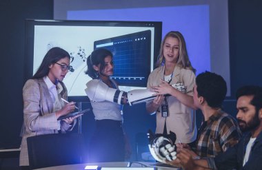 Çeşitli mühendisler ve tasarımcılar yüksek teknoloji yenilik laboratuvarında robotik protez kolun geliştirilmesi konusunda işbirliği yaparlar. Takım çalışması, teknolojik yaratıcılık, insan odaklı ürün tasarımı