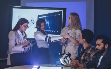 Çeşitli mühendisler ve tasarımcılar yüksek teknoloji yenilik laboratuvarında robotik protez kolun geliştirilmesi konusunda işbirliği yaparlar. Takım çalışması, teknolojik yaratıcılık, insan odaklı ürün tasarımı