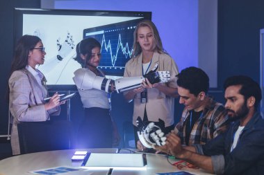 Çeşitli mühendisler ve tasarımcılar yüksek teknoloji yenilik laboratuvarında robotik protez kolun geliştirilmesi konusunda işbirliği yaparlar. Takım çalışması, teknolojik yaratıcılık, insan odaklı ürün tasarımı