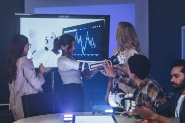 Çeşitli mühendisler ve tasarımcılar yüksek teknoloji yenilik laboratuvarında robotik protez kolun geliştirilmesi konusunda işbirliği yaparlar. Takım çalışması, teknolojik yaratıcılık, insan odaklı ürün tasarımı