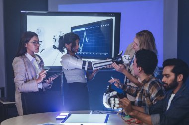 Çeşitli mühendisler ve tasarımcılar yüksek teknoloji yenilik laboratuvarında robotik protez kolun geliştirilmesi konusunda işbirliği yaparlar. Takım çalışması, teknolojik yaratıcılık, insan odaklı ürün tasarımı