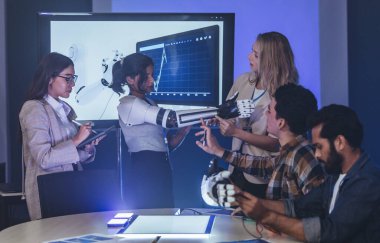 Çeşitli mühendisler ve tasarımcılar yüksek teknoloji yenilik laboratuvarında robotik protez kolun geliştirilmesi konusunda işbirliği yaparlar. Takım çalışması, teknolojik yaratıcılık, insan odaklı ürün tasarımı