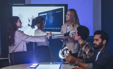 Çeşitli mühendisler ve tasarımcılar yüksek teknoloji yenilik laboratuvarında robotik protez kolun geliştirilmesi konusunda işbirliği yaparlar. Takım çalışması, teknolojik yaratıcılık, insan odaklı ürün tasarımı