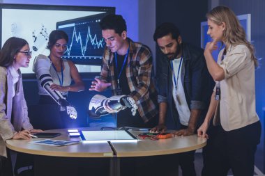 Çeşitli mühendisler ve tasarımcılar yüksek teknoloji yenilik laboratuvarında robotik protez kolun geliştirilmesi konusunda işbirliği yaparlar. Takım çalışması, teknolojik yaratıcılık, insan odaklı ürün tasarımı