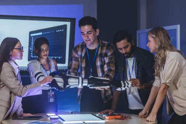 Çeşitli mühendisler ve tasarımcılar yüksek teknoloji yenilik laboratuvarında robotik protez kolun geliştirilmesi konusunda işbirliği yaparlar. Takım çalışması, teknolojik yaratıcılık, insan odaklı ürün tasarımı