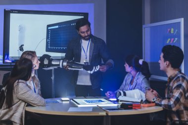 Çeşitli mühendisler ve tasarımcılar yüksek teknoloji yenilik laboratuvarında robotik protez kolun geliştirilmesi konusunda işbirliği yaparlar. Takım çalışması, teknolojik yaratıcılık, insan odaklı ürün tasarımı