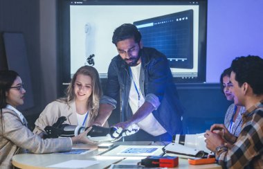 Çeşitli mühendisler ve tasarımcılar yüksek teknoloji yenilik laboratuvarında robotik protez kolun geliştirilmesi konusunda işbirliği yaparlar. Takım çalışması, teknolojik yaratıcılık, insan odaklı ürün tasarımı