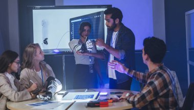 Çeşitli mühendisler ve tasarımcılar yüksek teknoloji yenilik laboratuvarında robotik protez kolun geliştirilmesi konusunda işbirliği yaparlar. Takım çalışması, teknolojik yaratıcılık, insan odaklı ürün tasarımı