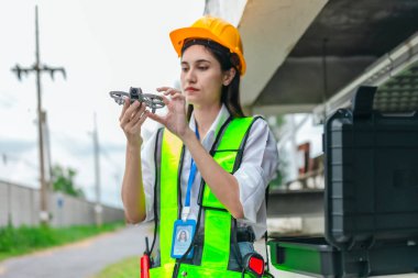 Kadın mühendis, pompalama sistemi ve çevreleyen altyapı üzerinde insansız hava aracı araştırması yapıyor. Mühendislik teftişinde modern teknolojinin kullanımı, bakım, akıllı altyapı geliştirme