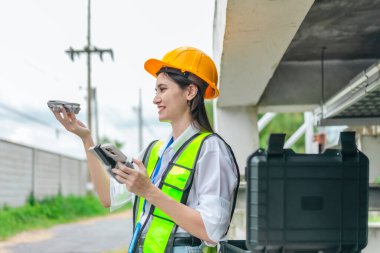 Kadın mühendis, pompalama sistemi ve çevreleyen altyapı üzerinde insansız hava aracı araştırması yapıyor. Mühendislik teftişinde modern teknolojinin kullanımı, bakım, akıllı altyapı geliştirme