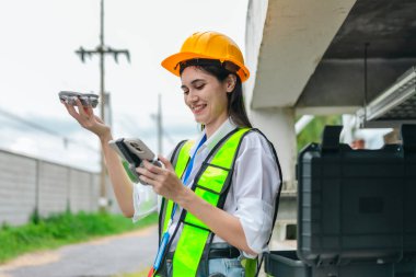 Kadın mühendis, pompalama sistemi ve çevreleyen altyapı üzerinde insansız hava aracı araştırması yapıyor. Mühendislik teftişinde modern teknolojinin kullanımı, bakım, akıllı altyapı geliştirme