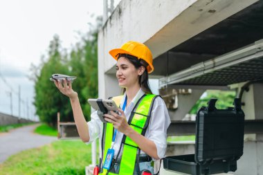 Kadın mühendis, pompalama sistemi ve çevreleyen altyapı üzerinde insansız hava aracı araştırması yapıyor. Mühendislik teftişinde modern teknolojinin kullanımı, bakım, akıllı altyapı geliştirme